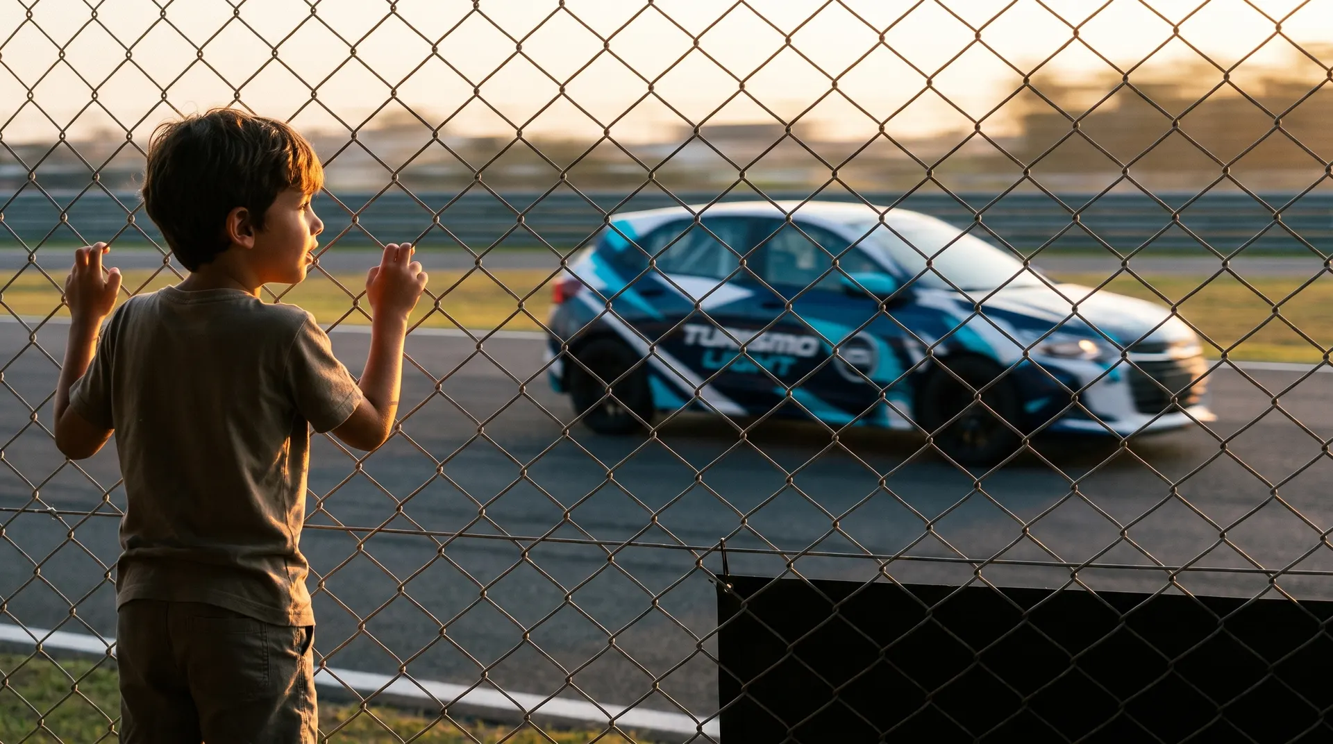 Criança na grade do autódromo vendo o carro Turismo Light passar